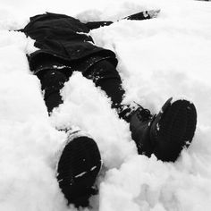 a person laying in the snow with their feet up