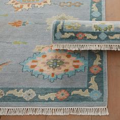 two rugs on the floor, one with fringe ends and another with floral designs