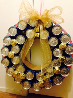 a wreath made out of beer cans with a bow on the front and side door