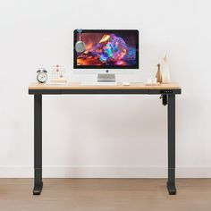 a computer monitor sitting on top of a wooden desk next to a clock and other items