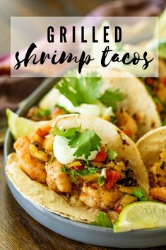 grilled shrimp tacos on a plate with limes and cilantro