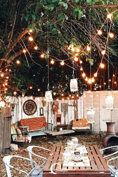 an outdoor seating area with lights strung from the trees