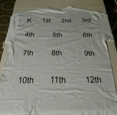 a white t - shirt with numbers and times on it sitting on top of a table