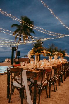 a long table set up for dinner on the beach