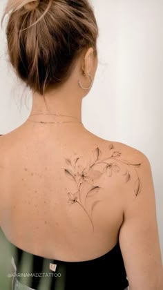 the back of a woman's shoulder with flowers on it