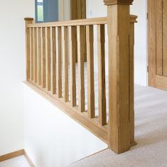 an empty room with wooden railings and white carpet