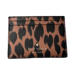 an animal print card case with the name kate spade new york written in gold on it