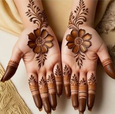 two hands with henna designs on them, one is brown and the other is white