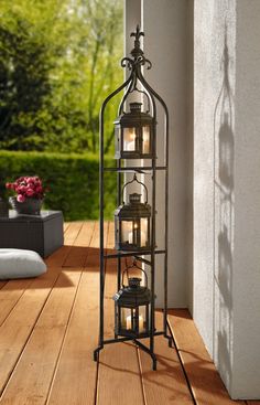 an iron lantern with candles inside on a porch