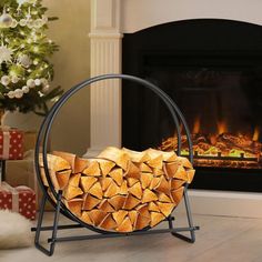 a fire place with logs in front of a christmas tree and presents on the floor