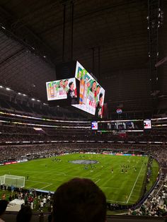 a soccer stadium filled with lots of people watching the game on big screen tvs