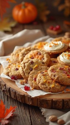 cookies with cream cheese and cranberries are on a wooden platter next to pumpkins