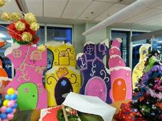 an office decorated for christmas with brightly colored paper cutouts and decorations on the desk