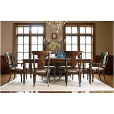 a dining room table with chairs and chandelier in front of two large windows