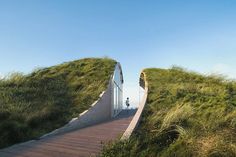 an unusual house built into the side of a hill with grass growing on it's sides