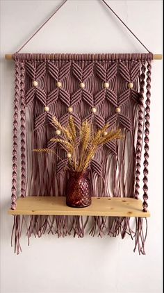 a decorative wall hanging with flowers and plants on it's shelf in front of a white wall