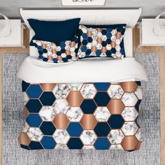 a bed with blue and white bedspread, pillows and blankets on top of it