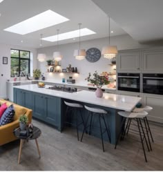 a kitchen and living room with skylights in the ceiling, couches, tables and chairs