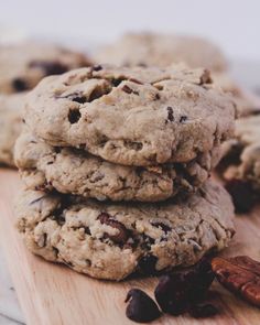 cookies and raisins are stacked on a cutting board next to a glass of milk