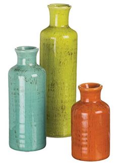 three different colored vases sitting next to each other