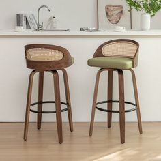 two wooden stools sitting next to each other in front of a kitchen counter top