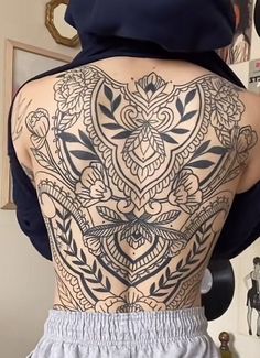 the back of a woman's body with tattoos on it