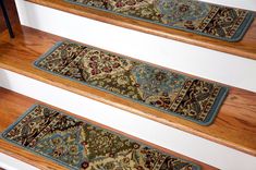 three rugs are on the stairs in front of a stair case with an ornate design