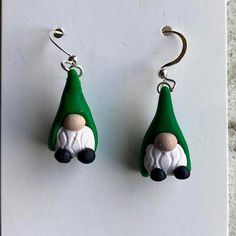 the earrings are green and white with a gnome's head