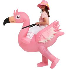 a woman riding on the back of a pink flamingo inflatable