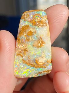 a hand holding a piece of opalite in it's palm