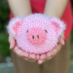 a person holding a pink stuffed animal in their hands with the pig on it's face