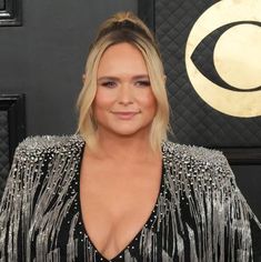 a woman in a black and silver dress posing for a photo on the red carpet