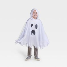 a young boy dressed in a ghost costume