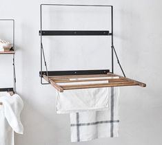 an ironing board and towel rack are hanging on the wall next to two white towels