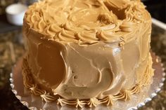 a frosted cake sitting on top of a glass plate