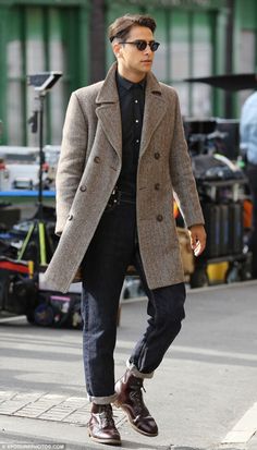 a man walking down the street wearing a coat