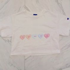 Champion Cropped Tee. Conversation Heart Print For Valentine’s Day. Never Worn! Size Xs- Fits A Size S Top White Tops With Heart Graphic For Valentine's Day, Cute White Top With Heart Graphic, White Crew Neck Top With Heart Patch, Cute Heart Print Tops For Valentine's Day, Casual White Heart-shaped Top, Cute Crew Neck Top With Heart Patch, White Casual Top With Heart Patch, Casual White Top With Heart Patch, Cute Cotton Tops With Heart Print