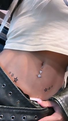 a woman's stomach with stars tattoo on her lower body and the bottom part of her stomach