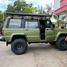 a man standing next to a green jeep