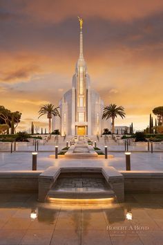 a large white church with steps leading up to the front entrance and palm trees in the background