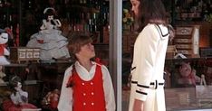 two women standing in front of a store window looking at stuffed animals and teddy bears