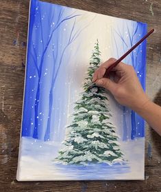 someone is painting a christmas tree on a canvas