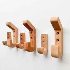 three wooden hooks are hanging on the wall