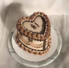 a heart - shaped cake on a plate with gold beads and rings around the edges