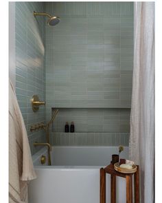 a white bath tub sitting next to a wooden stool