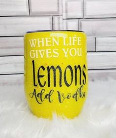 a yellow coffee cup with the words lemons ade word written on it, sitting on a fluffy white surface