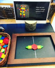 a wooden frame sitting on top of a table next to a basket filled with magnets