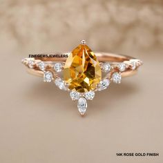 an engagement ring with a pear shaped yellow sapphire surrounded by white topaz and diamonds