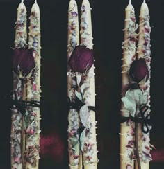 three decorative candles with flowers on them