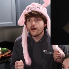 a man wearing a pink bunny hat in the kitchen